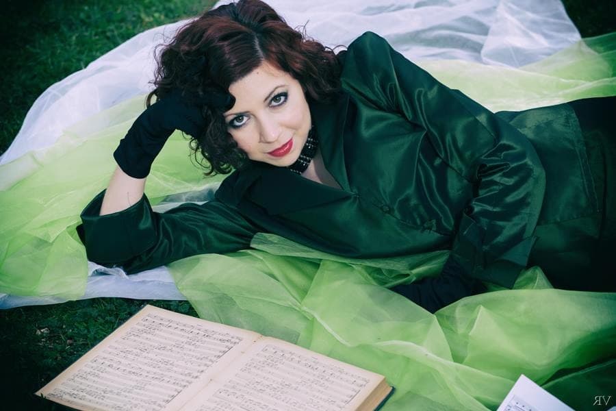 Maira Melchionda in an emerald gown with a music score — editorial portrait